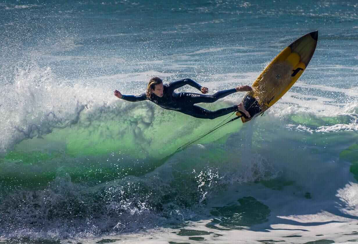 barbat in wetsuit facand surf