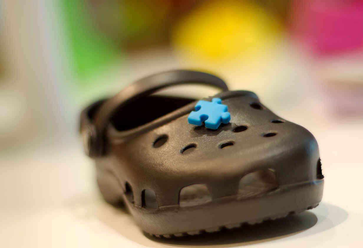 saboti Crocs negrii cu aplicatie piesa de puzzle albastra