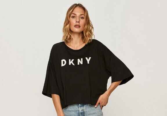 femeie cu tricou negru cu maneci scurte si inscriptie alba DKNY