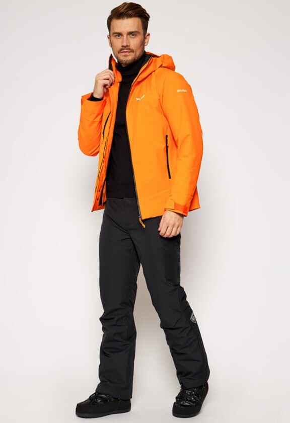 barbat cu geaca portocalie cu logo Salewa, bluza neagra si pantaloni de schi negrii