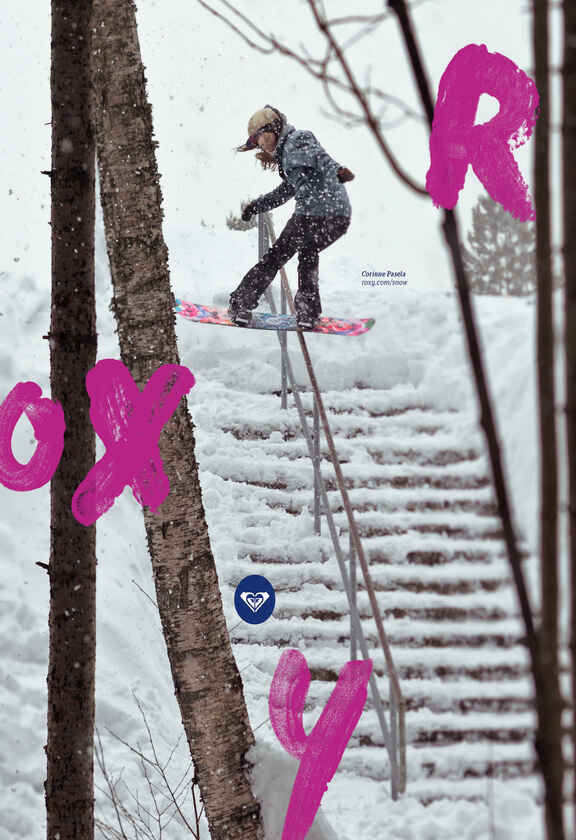 femeie cu geaca si pantaloni de snowboarding pe snowboard iarna